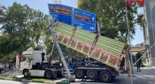 Seyir halindeki kamyon kasası açılınca yol levhasına takıldı