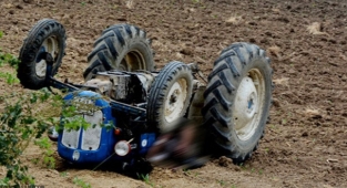 Devrilen traktörün altında kaldı